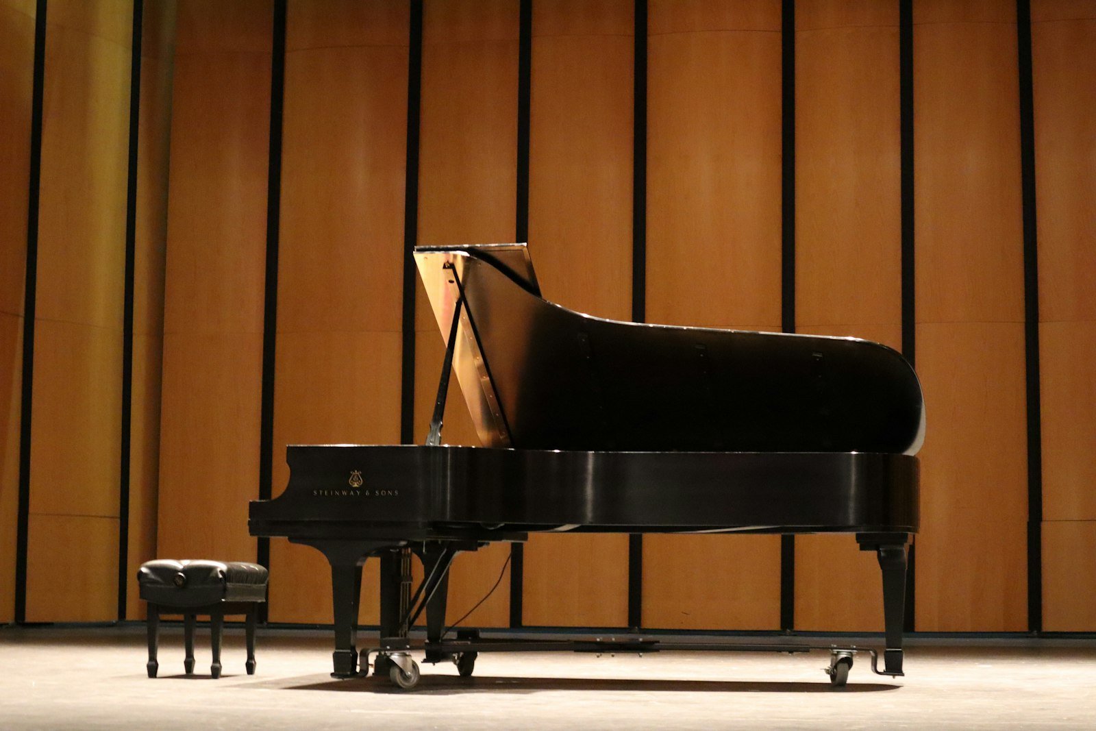 Piano de cola elegante en una sala de conciertos, imagen principal de la página de inicio